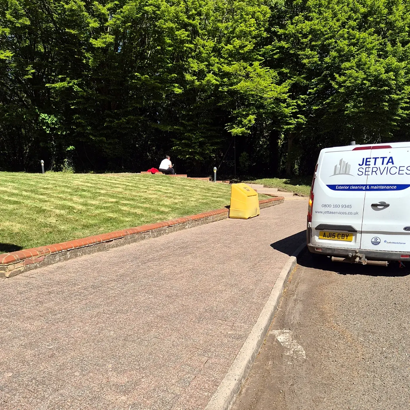 Freshly striped lawn at a commercial site with the JETTA Services van